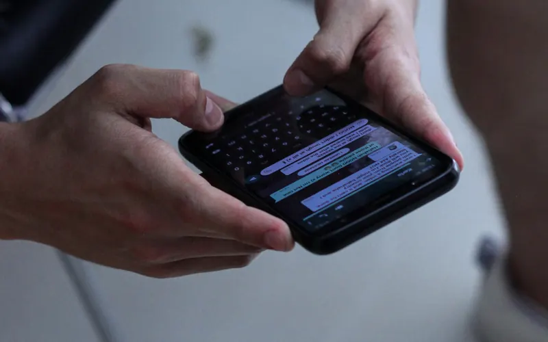 Hands typing a message in a chat app on a phone